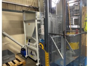 image shows a new swarf briquetting machine with a swarf bin lifter installed at Drury's Precision